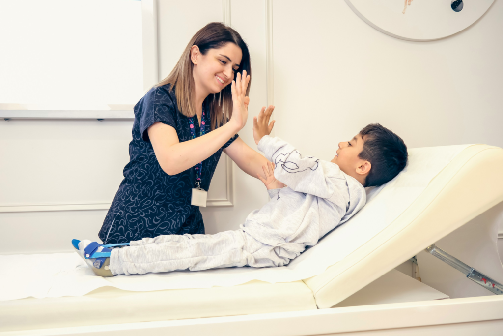 Criança com sequelas neurológicas realizando fisioterapia em centro especializado em reabilitação pediátrica, acompanhada por terapeuta.